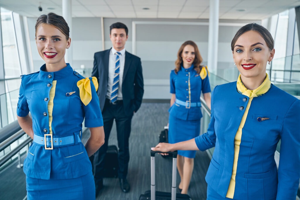 smiling stylish flight attendants their elegant colleague posing camera